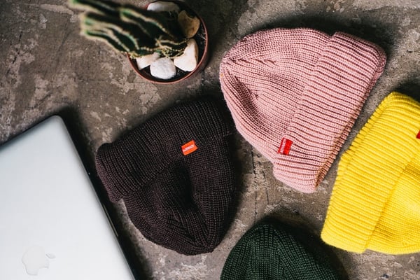 Picture shows four beanies on a marble counter, representing beanies as some of the best dropshipping products.