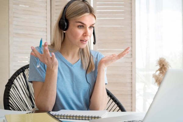 A woman using a headphone having a meeting on her computer, earning money online.